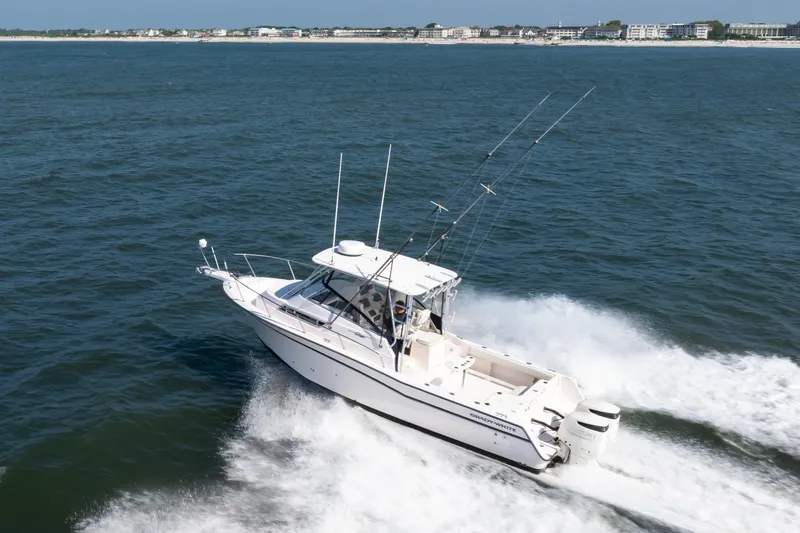 The Image of 1997 Grady-White Marlin 300 boat cruising on open water near coastline. - 0