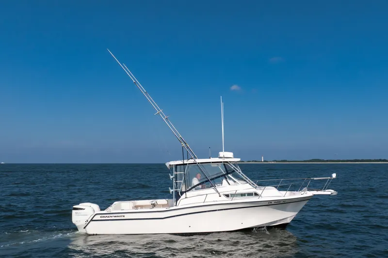 Slide: The Image of 1997 Grady-White Marlin 300 boat cruising on open water near coastline. - 16