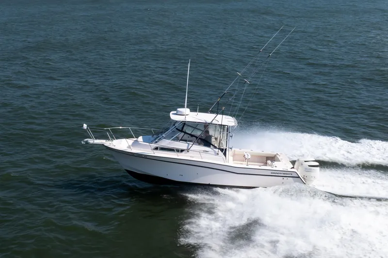 Slide: The Image of 1997 Grady-White Marlin 300 boat cruising on open water under clear blue sky. - 36