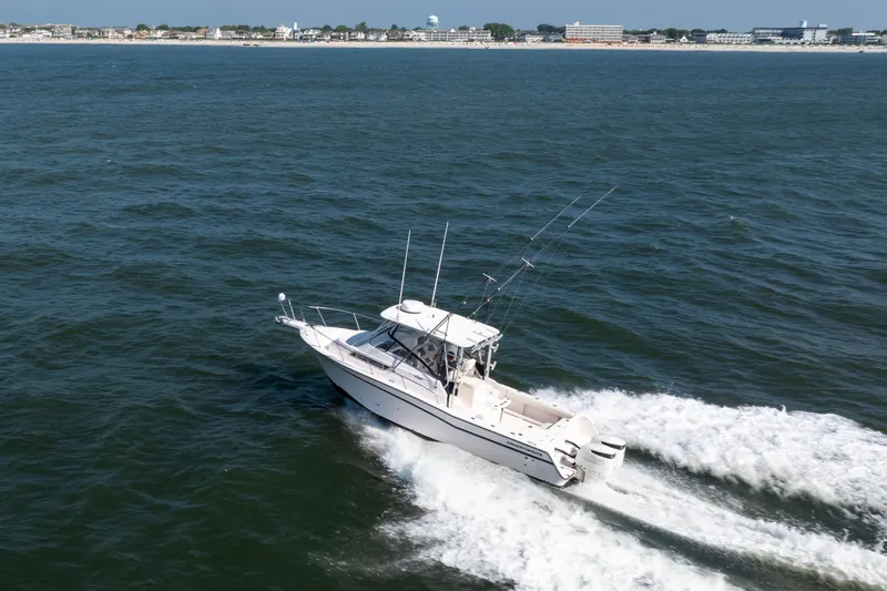 Slide: The Image of 1997 Grady-White Marlin 300 boat on open sea under clear blue sky. - 41