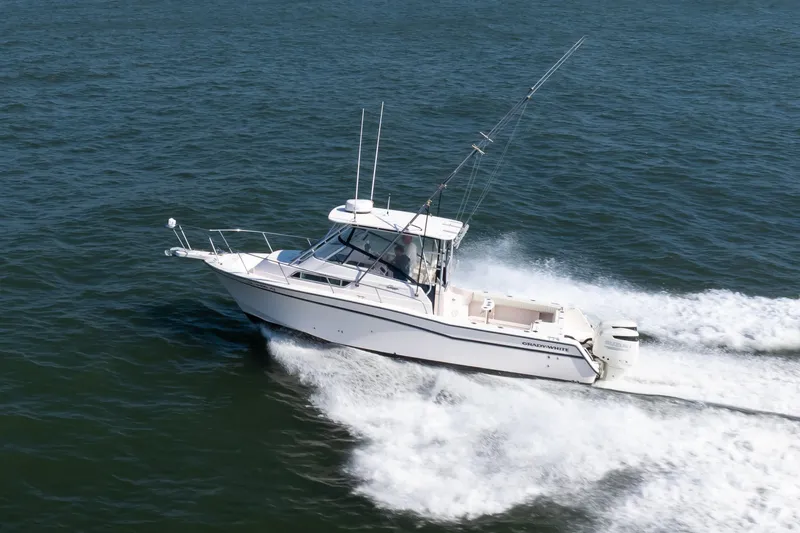 Slide: The Image of 1997 Grady-White Marlin 300 boat cruising on open water under clear blue sky. - 42
