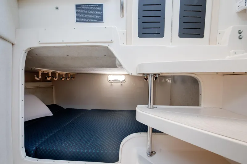 Slide: The Image of 1997 Grady-White Marlin 300 boat deck with seating and rod holders on the water. - 57