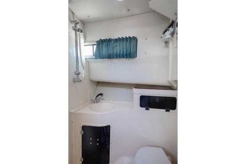 Slide: The Image of 1997 Grady-White Marlin 300 boat bathroom with sink, shower, and window curtain. - 63