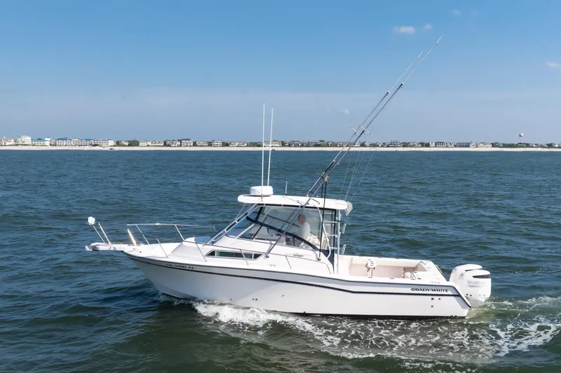Slide: The Image of 1997 Grady-White Marlin 300 boat cruising swiftly on open water. - 7