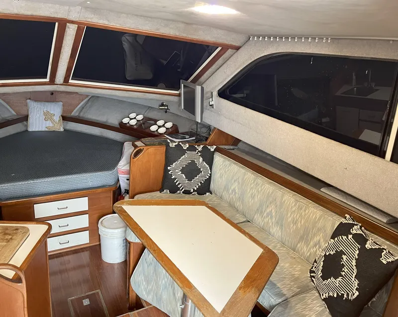 Slide: The Image of 1988 Pacemaker 308 boat interior with cozy seating, table, and bed. - 12