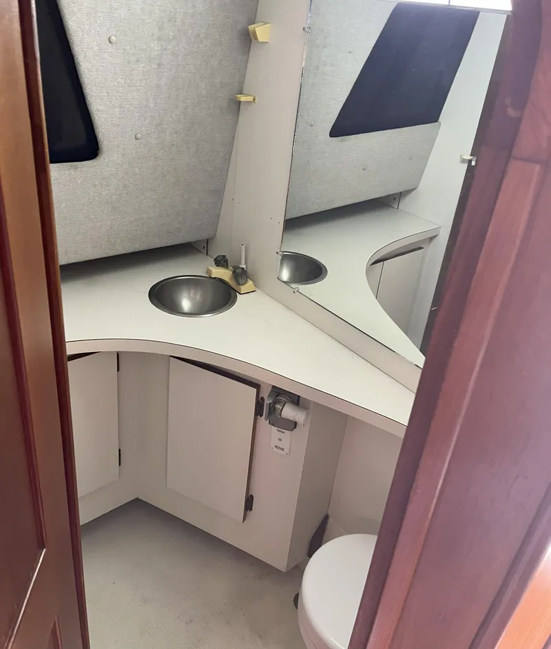 Slide: The Image of Compact bathroom in a 1988 Pacemaker 308 boat, featuring a sink and mirror. - 17