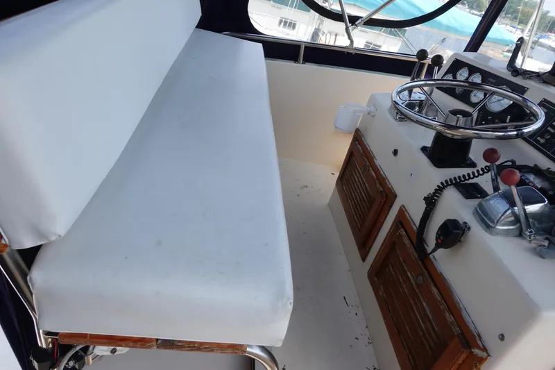 Slide: The Image of 1988 Pacemaker 308 boat helm with steering wheel, controls, and cushioned bench seat. - 5