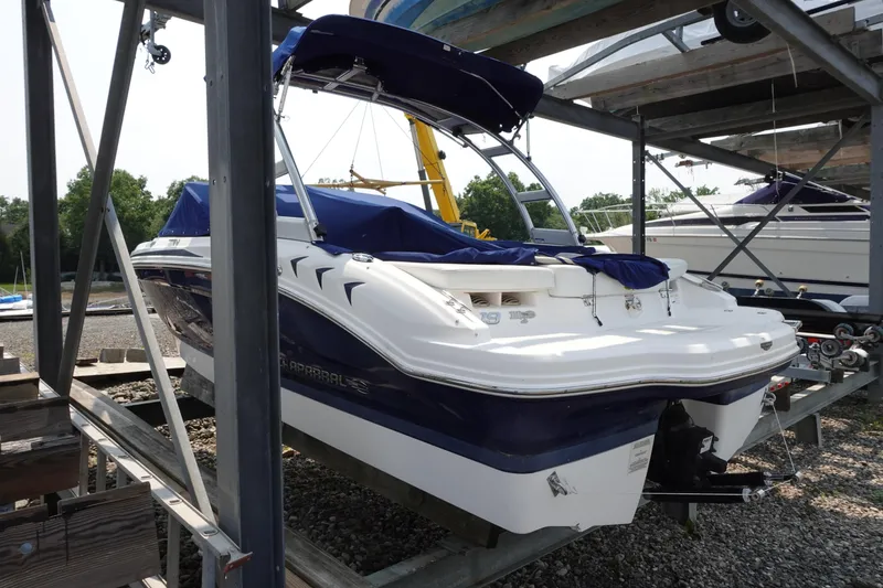Slide: The Image of 2013 Chaparral 19 Sport H2O boat on a storage rack, covered and ready for use. - 2