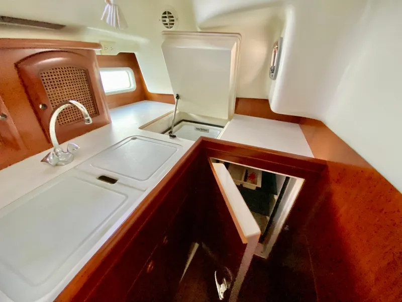 Slide: The Image of Interior view of 1999 Beneteau 411 yacht kitchen with sink and wooden cabinetry. - 15