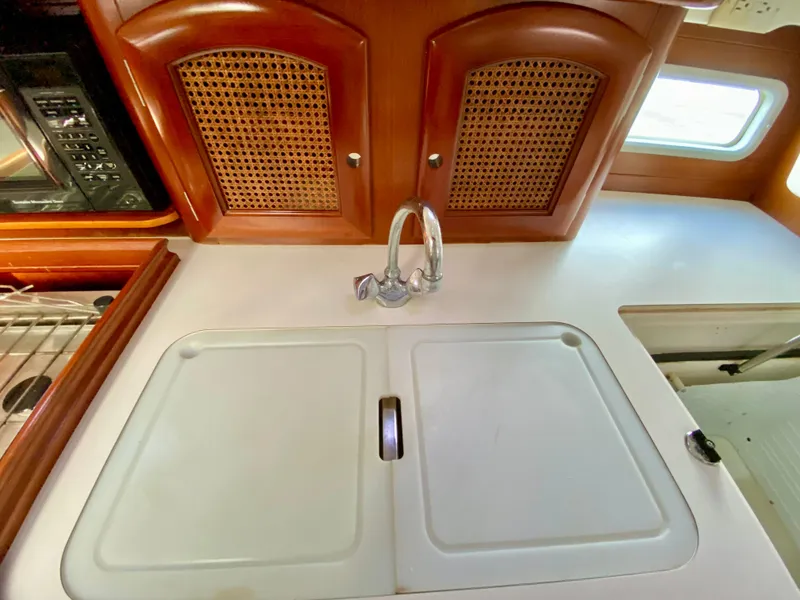 Slide: The Image of Interior of 1999 Beneteau 411 yacht kitchen with sink and wooden cabinets. - 16