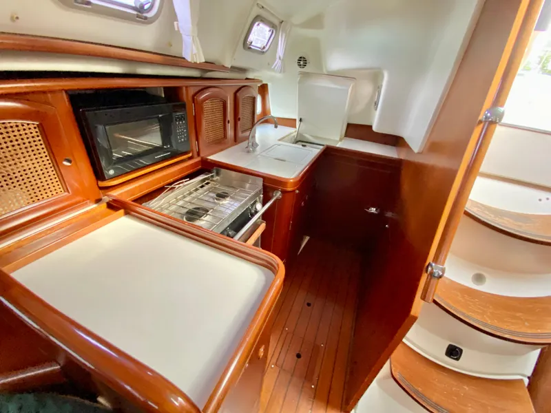Slide: The Image of Interior of 1999 Beneteau 411 yacht kitchen with wood finish and modern appliances. - 17