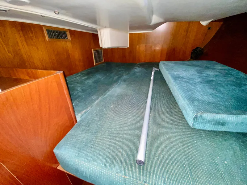 Slide: The Image of Interior cabin of 1999 Beneteau 411 sailboat with teal cushions and wooden paneling. - 20
