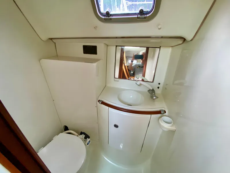Slide: The Image of Bathroom interior of a 1999 Beneteau 411 yacht, featuring a sink and toilet. - 22