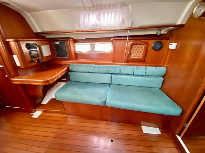 Slide: The Image of Interior of 1999 Beneteau 411 yacht with teal sofa and wooden cabinetry. - 23
