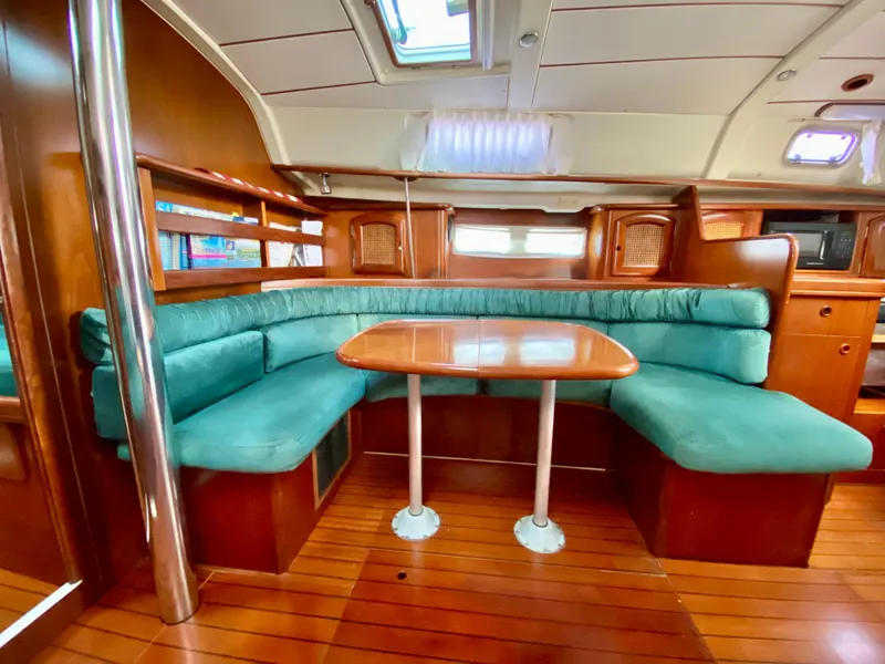 Slide: The Image of Luxurious interior of 1999 Beneteau 411 yacht with teal seating and wooden table. - 24
