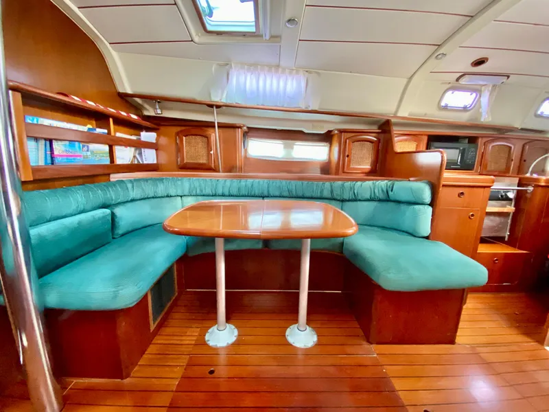 Slide: The Image of Interior of 1999 Beneteau 411 yacht with wooden dining area and teal seating. - 25