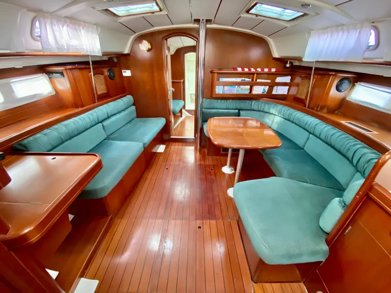 Slide: The Image of Interior of 1999 Beneteau 411 sailboat with wood finish and green seating. - 32