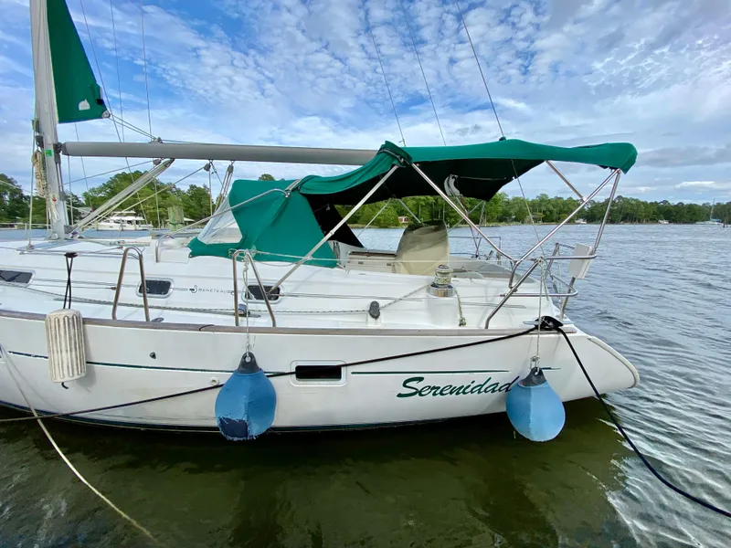 Slide: The Image of Sailboat Beneteau 411, 1999 model, named Serenidad, docked on a calm lake. - 4