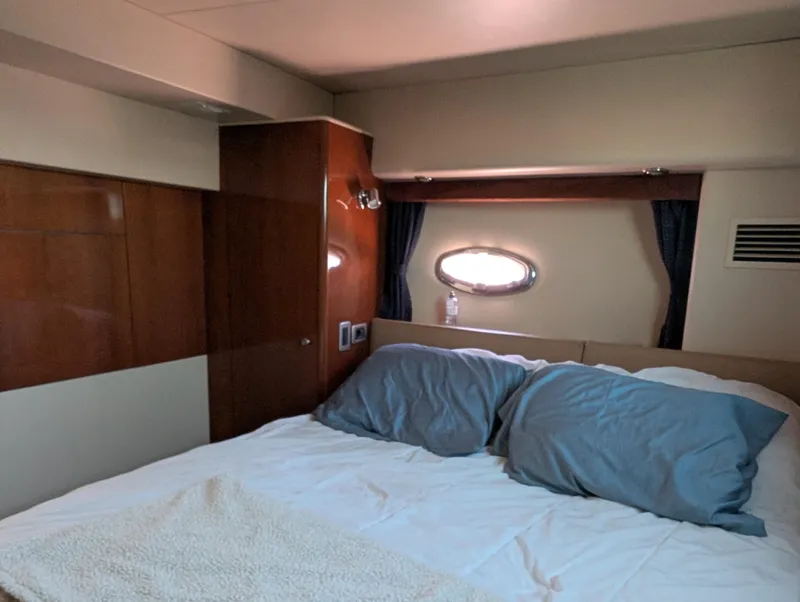 Slide: The Image of Cozy bedroom interior of 2006 Meridian 368 yacht with wooden paneling and porthole window. - 13
