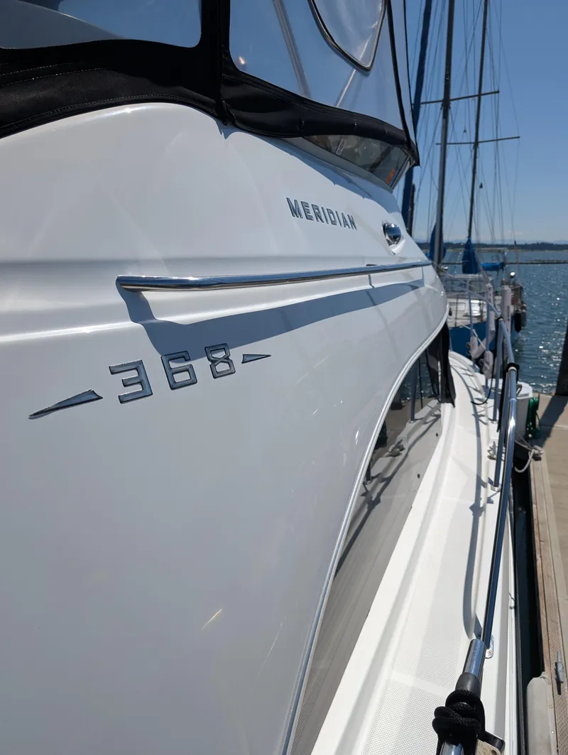 Slide: The Image of 2006 Meridian 368 yacht docked, showcasing sleek design and branding. - 2