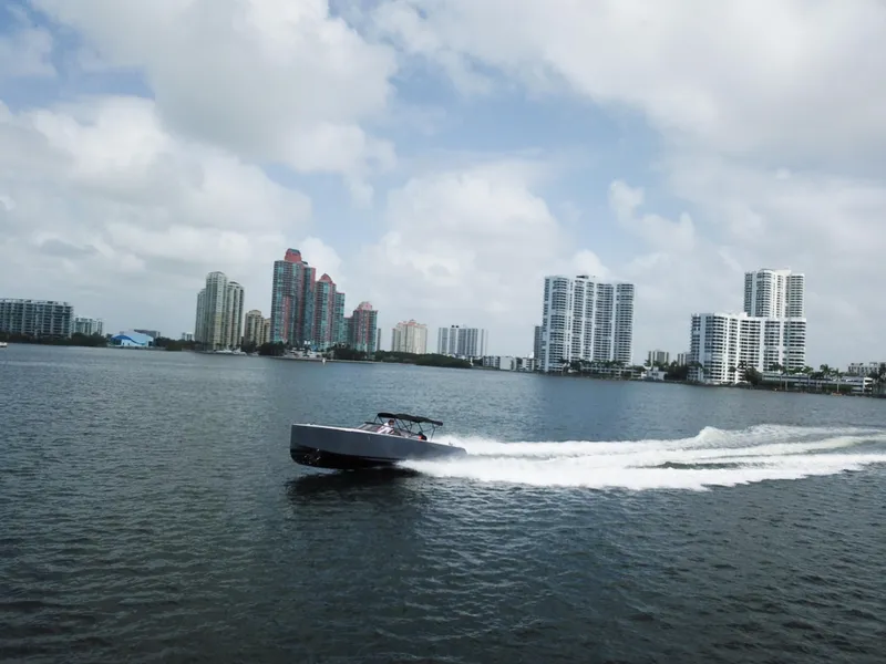 Slide: The Image of VanDutch 30 boat cruising on water with city skyline in background, 2016 model. - 13