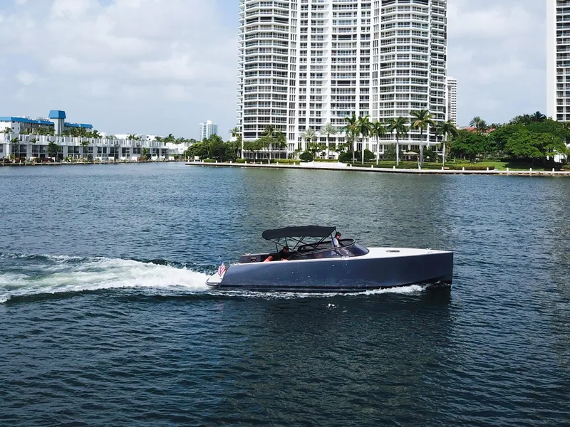 Slide: The Image of 2016 VanDutch 30 yacht cruising on a sunny day near waterfront buildings. - 15