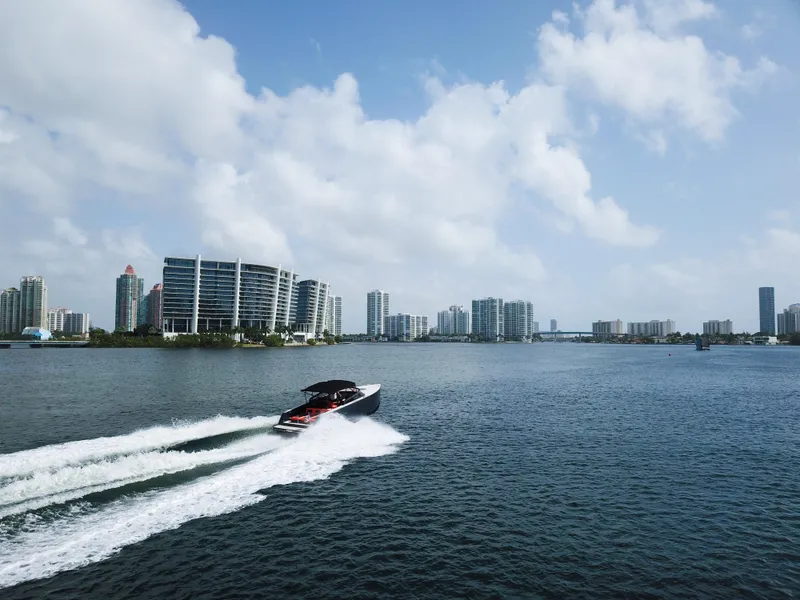 Slide: The Image of 2016 VanDutch 30 yacht cruising on water with city skyline in background. - 20