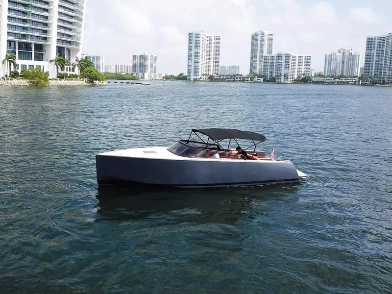 Slide: The Image of 2016 VanDutch 30 yacht cruising near modern waterfront buildings. - 26