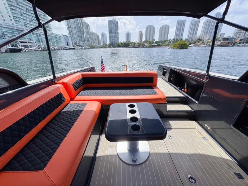 Slide: The Image of Luxurious 2016 VanDutch 30 yacht interior with orange and black seating, city skyline view. - 3