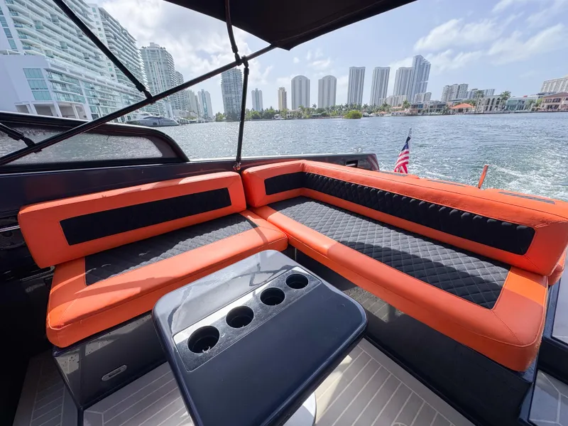 Slide: The Image of VanDutch 30 yacht interior with orange seating, cup holders, and city skyline view. - 4