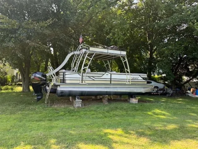 Slide: The Image of 2017 Crest Caribbean 250 L pontoon boat on blocks, surrounded by trees and grass. - 3