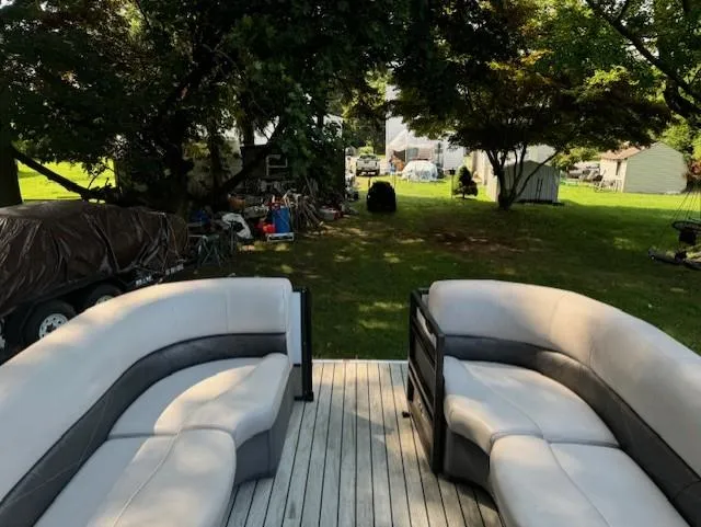 Slide: The Image of Pontoon boat interior with gray seating, Crest Caribbean 250 L, 2017 model, parked in a grassy yard. - 6