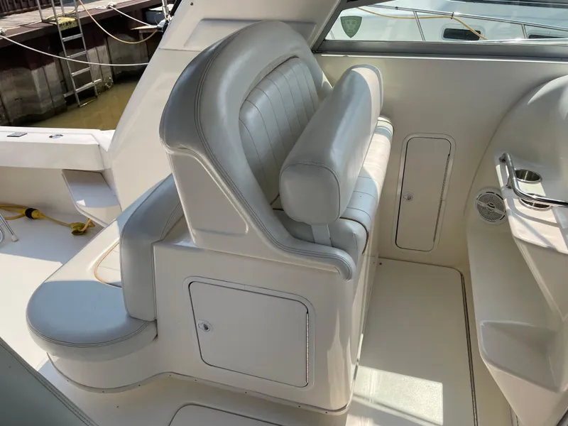 Slide: The Image of 1997 Sea Ray 330 Express boat interior with white leather seating and storage compartments. - 10