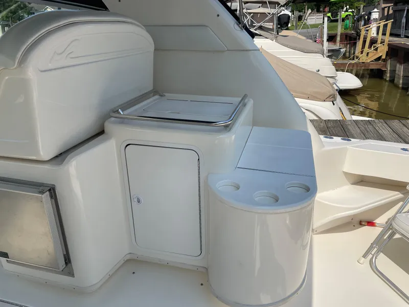 Slide: The Image of 1997 Sea Ray 330 Express boat interior with storage and cup holders, docked at marina. - 12