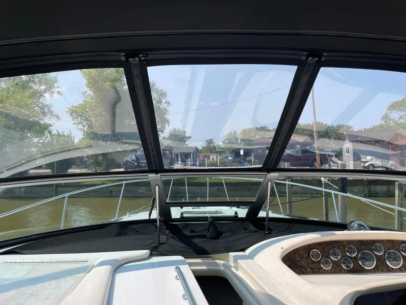 Slide: The Image of 1997 Sea Ray 330 Express boat dashboard view with clear windshield and waterway background. - 17