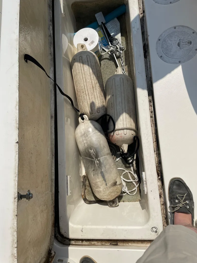 Slide: The Image of Storage compartment on a 1997 Sea Ray 330 Express with boat fenders and accessories. - 18