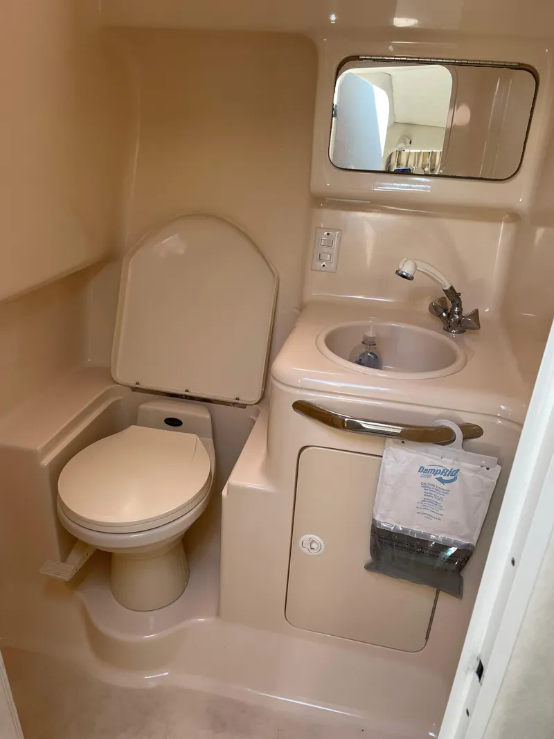 Slide: The Image of 1997 Sea Ray 330 Express bathroom with toilet, sink, and mirror. - 33