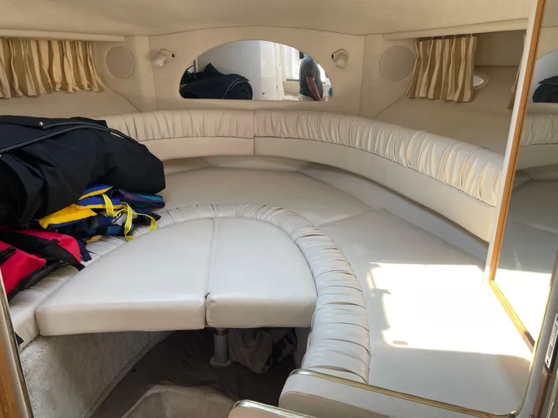 Slide: The Image of 1997 Sea Ray 330 Express cabin interior with white leather seating and stored life jackets. - 35