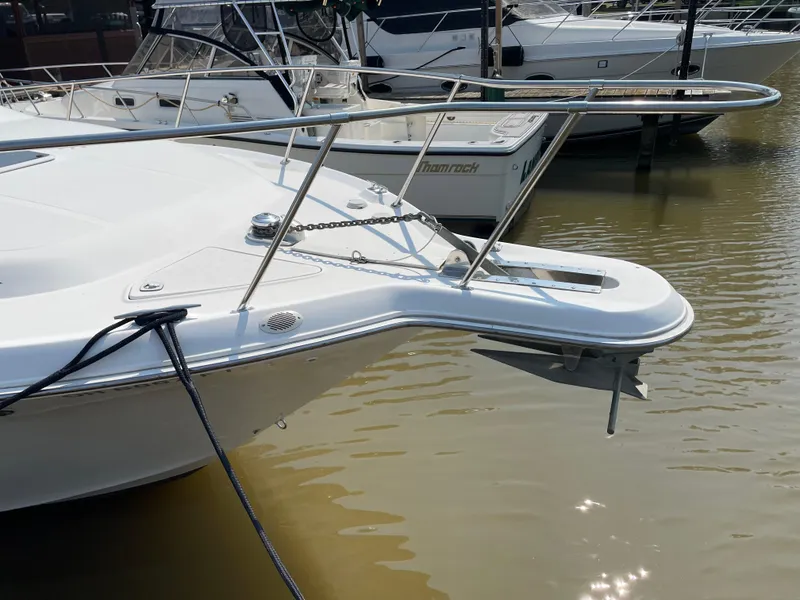 Slide: The Image of 1997 Sea Ray 330 Express boat docked, featuring a sleek bow and anchor. - 4