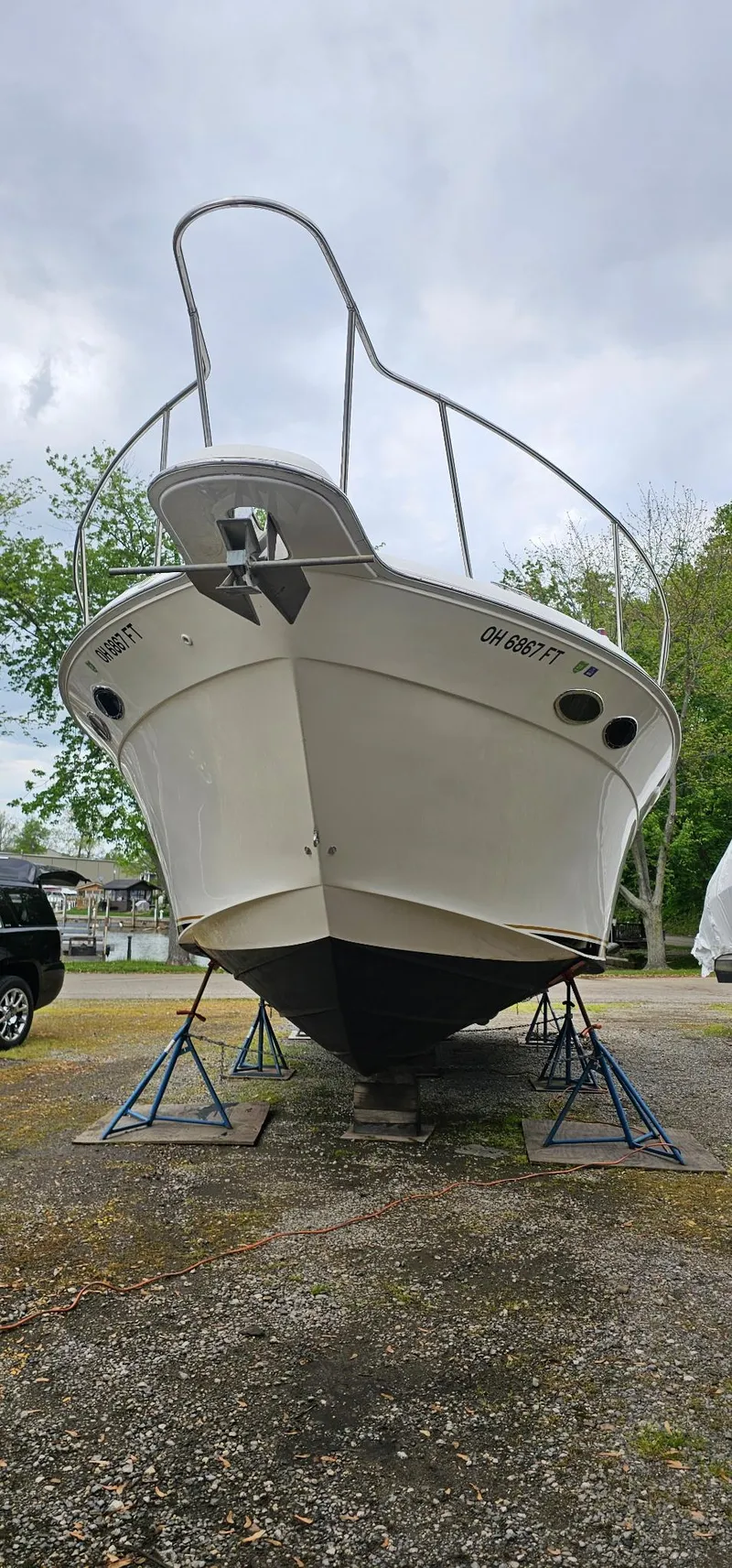 Slide: The Image of 1997 Sea Ray 330 Express boat on stands, viewed from the front, outdoors. - 49