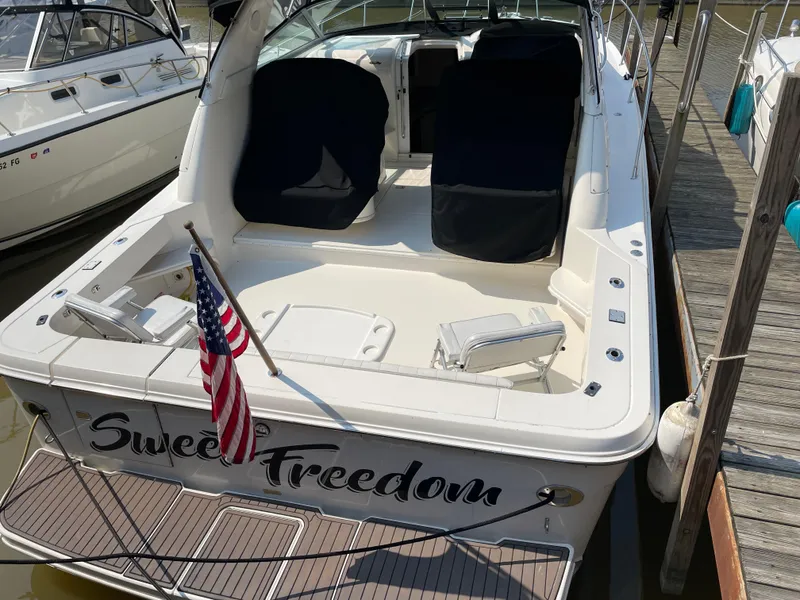 Slide: The Image of 1997 Sea Ray 330 Express boat docked, featuring "Sweet Freedom" name and American flag. - 5