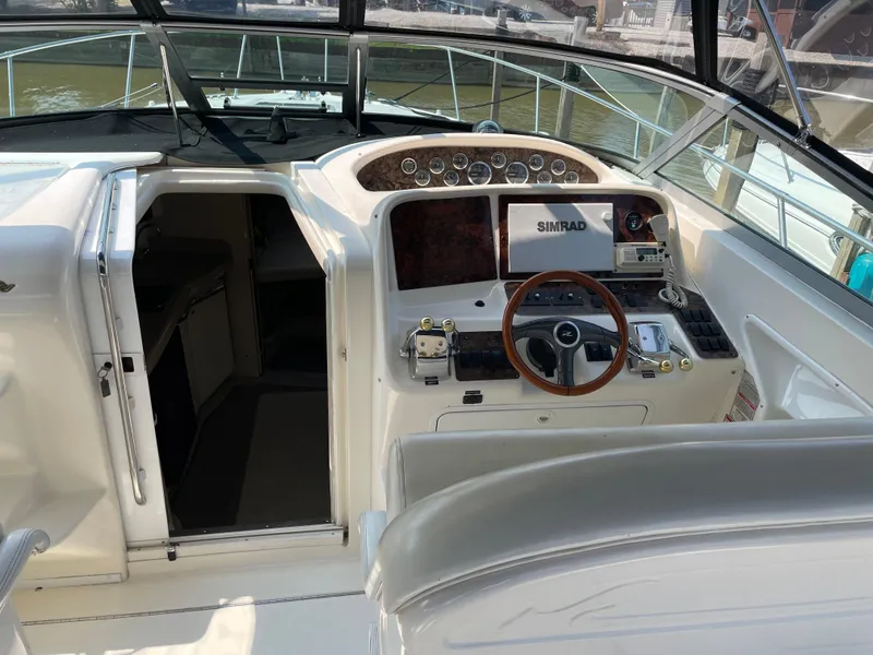 Slide: The Image of 1997 Sea Ray 330 Express boat cockpit with steering wheel and navigation equipment. - 6