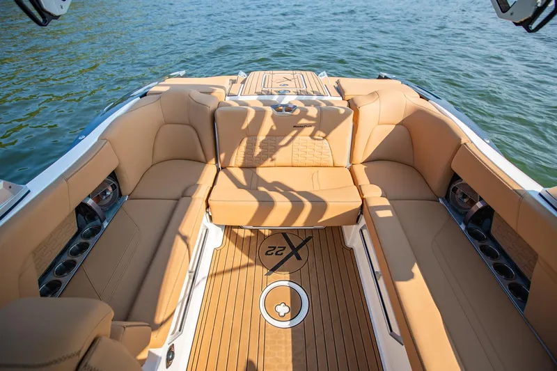 Slide: The Image of Luxurious 2021 MasterCraft X22 boat interior with tan seating and teak flooring on the water. - 17