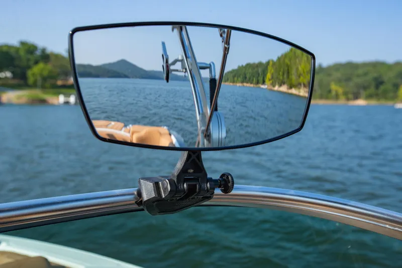 Slide: The Image of Rearview mirror on 2021 MasterCraft X22 boat reflecting scenic lake view. - 26