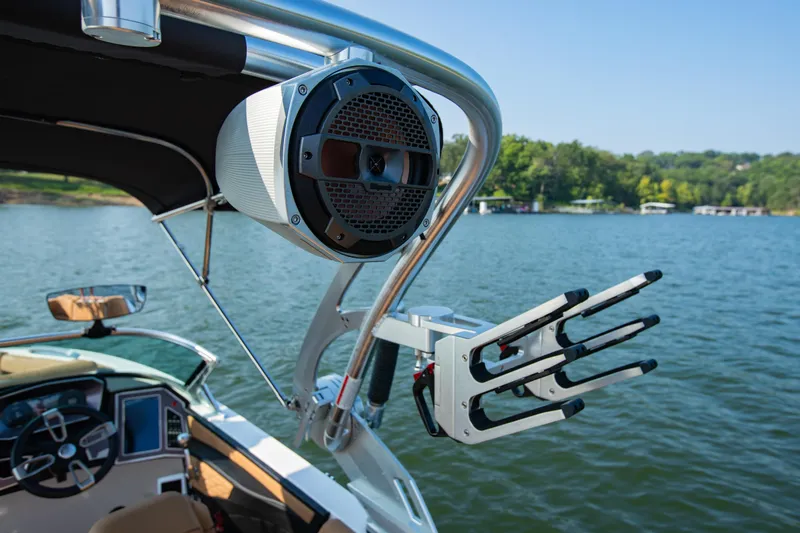 Slide: The Image of 2021 MasterCraft X22 boat with speaker and wakeboard rack on a lake. - 28