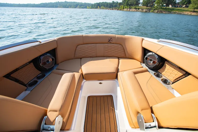 Slide: The Image of Luxurious seating on 2021 MasterCraft X22 boat, featuring tan upholstery and cup holders. - 30