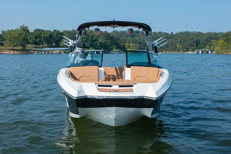 Slide: The Image of 2021 MasterCraft X22 boat on a lake, featuring sleek design and tan seating. - 4