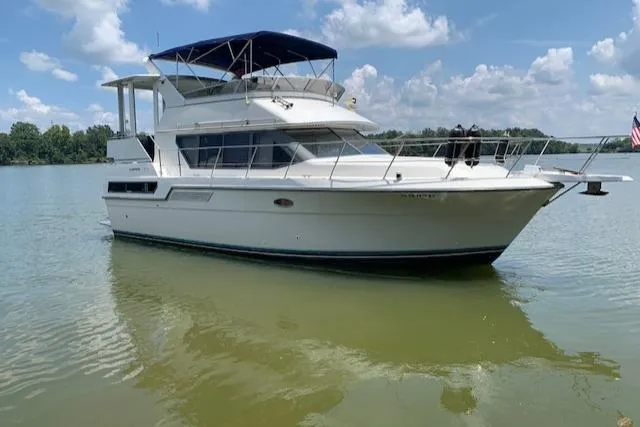 Slide: The Image of 1995 Carver 370 Aft Cabin yacht on calm water under blue sky. - 1