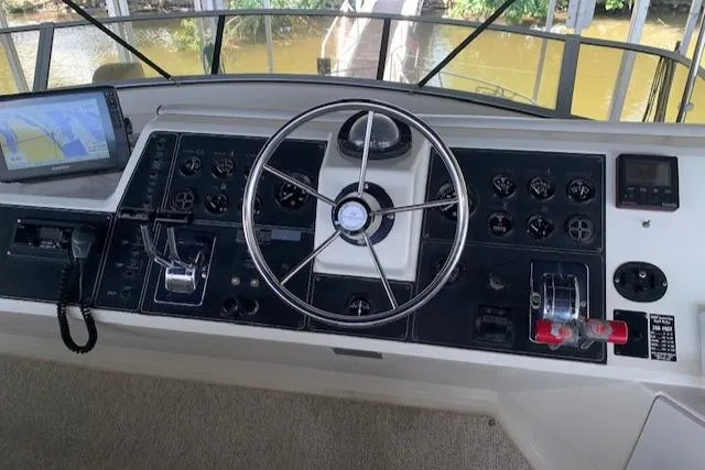 Slide: The Image of 1995 Carver 370 Aft Cabin helm with steering wheel, controls, and navigation equipment. - 10