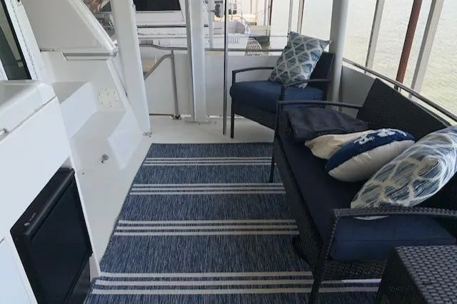 Slide: The Image of 1995 Carver 370 Aft Cabin interior with blue seating and striped rug. - 13
